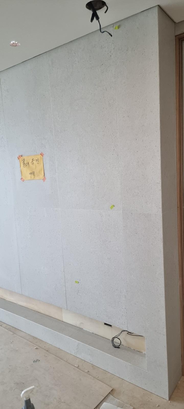 노란색 종이가 붙은 타일 벽면과 노출 전선