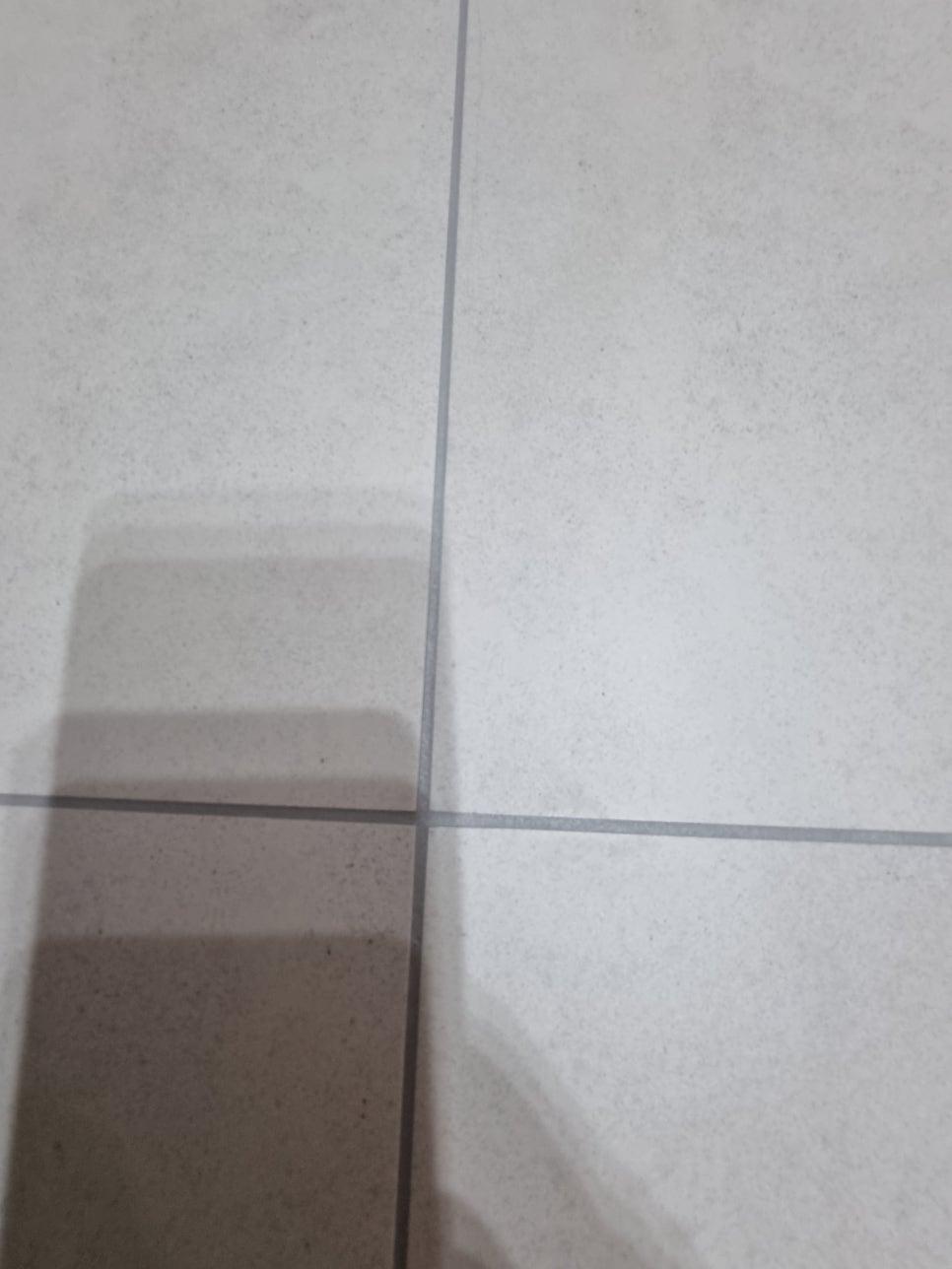 흰색 타일 바닥의 실리콘 틈새 근접샷