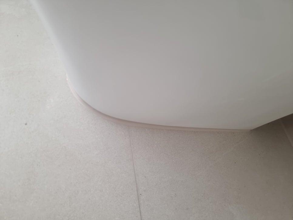 흰색 세라믹 타일 바닥과 욕조 하단 구역