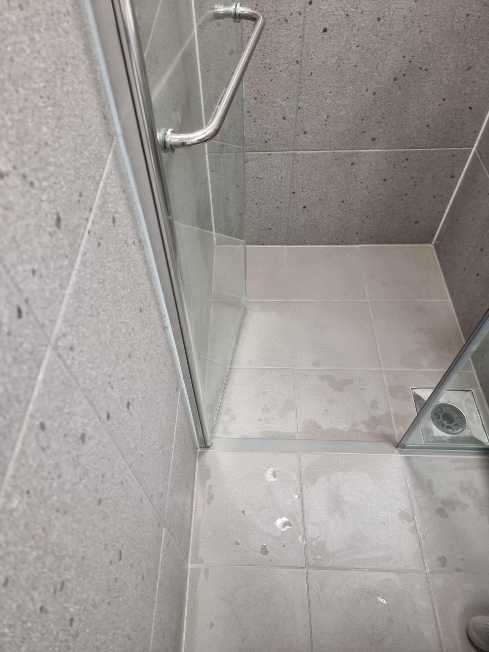 설비 일부가 보이는 욕실 바닥 근접 모습