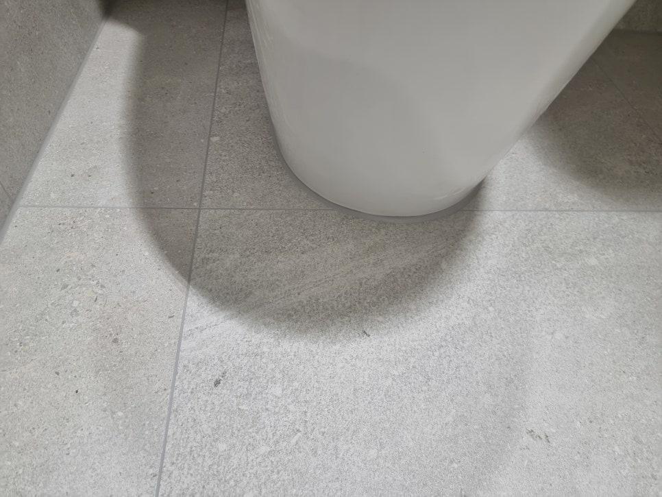흰색 세면대 하단과 타일 바닥의 접점