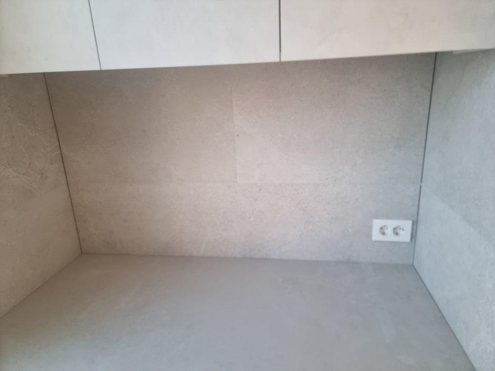 베이지색 타일 벽면과 밝은 색 상부 수납장