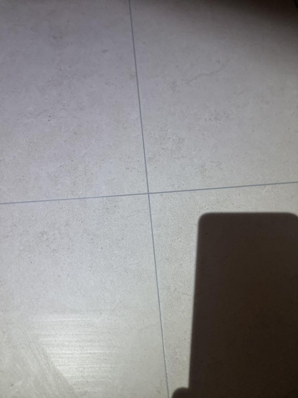 흰색 타일 바닥과 벽면이 만나는 근접 구간