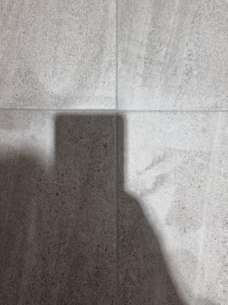 회색 타일 사이의 틈과 그림자가 보이는 근접 샷