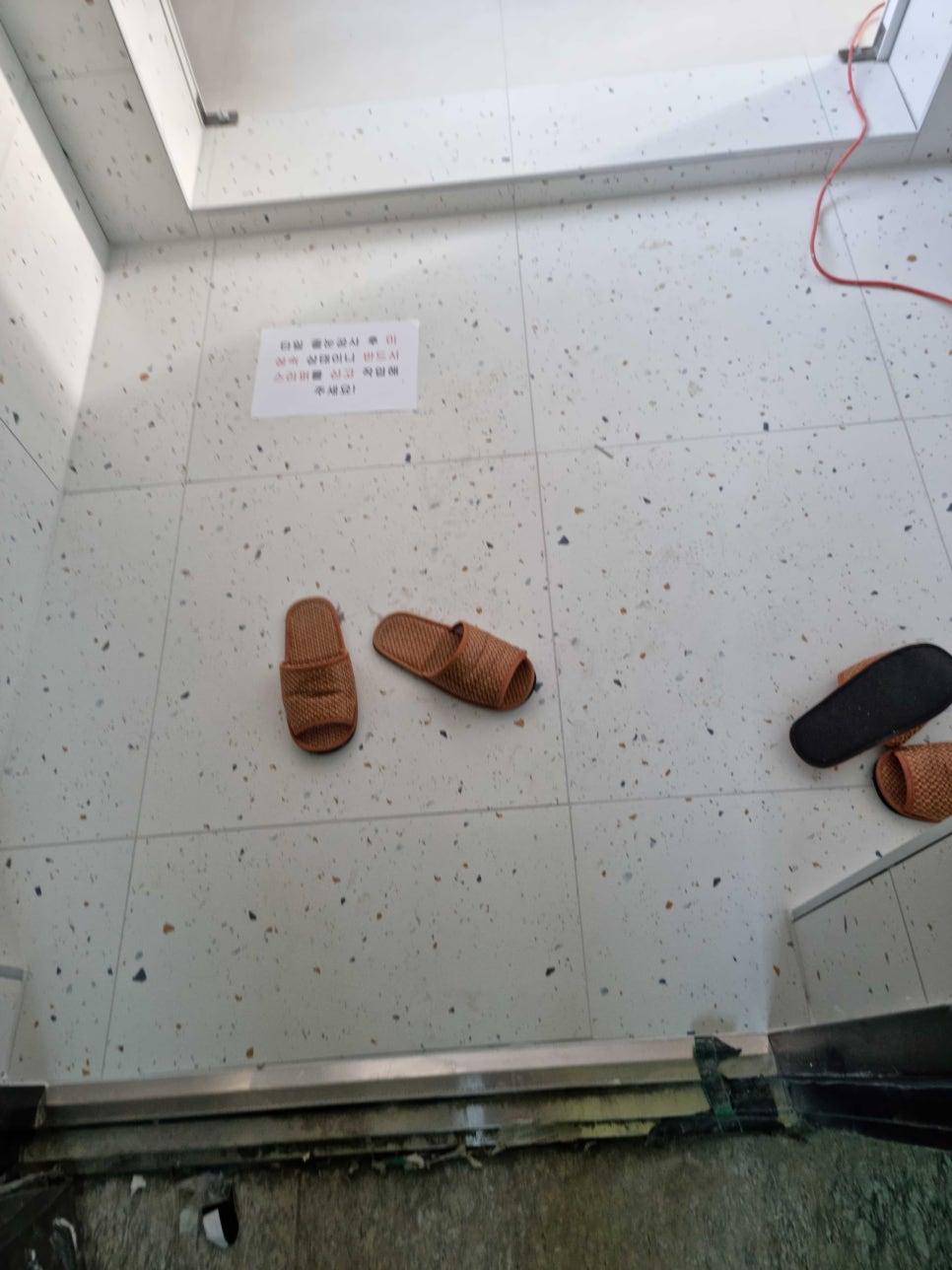 흰색 타일 바닥과 벽면의 종이가 보이는 현관 공사 과정