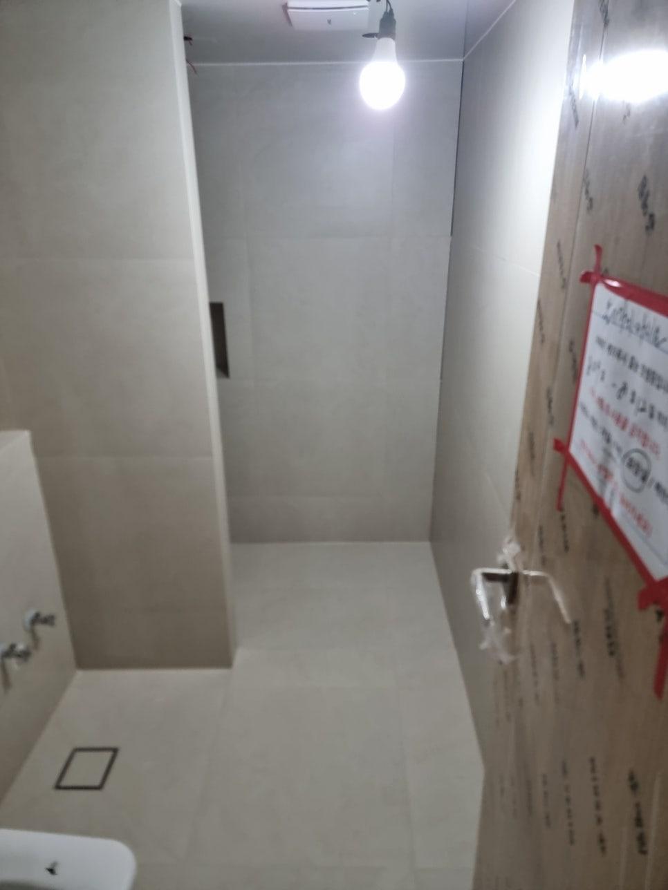 벽과 바닥에 흰색 타일이 시공 중인 빈 공간