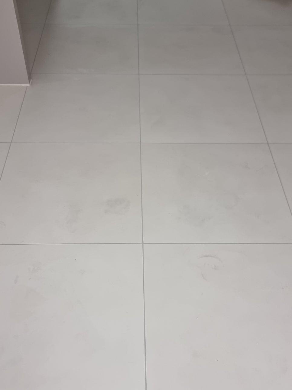 벽면과 맞닿은 흰색 타일 바닥의 모습