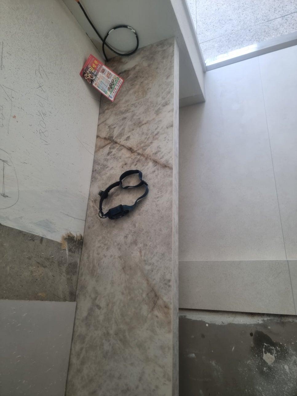 흰색 페인트 벽면과 석재 패턴 타일이 만나는 지점