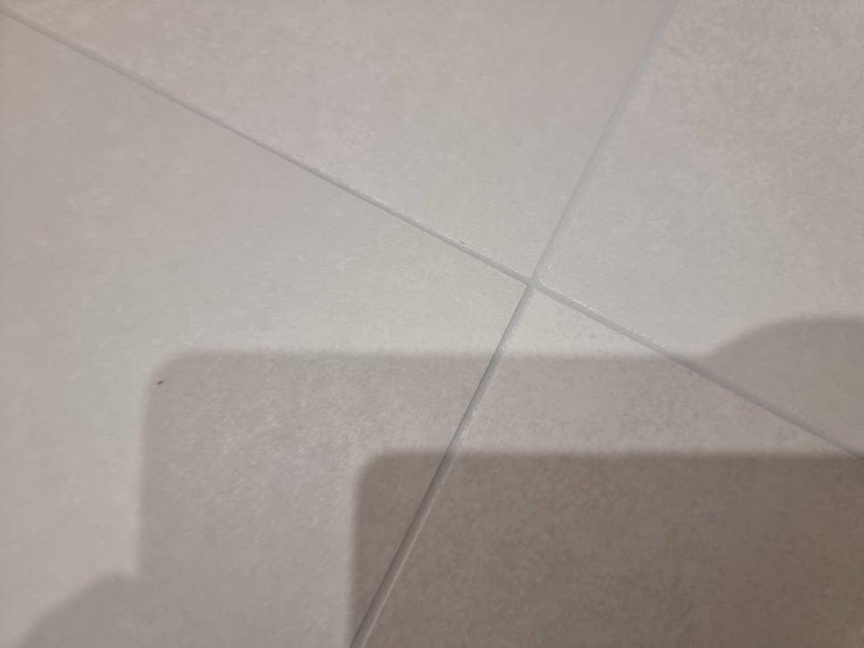 흰색 타일 사이의 기존 실리콘 틈새