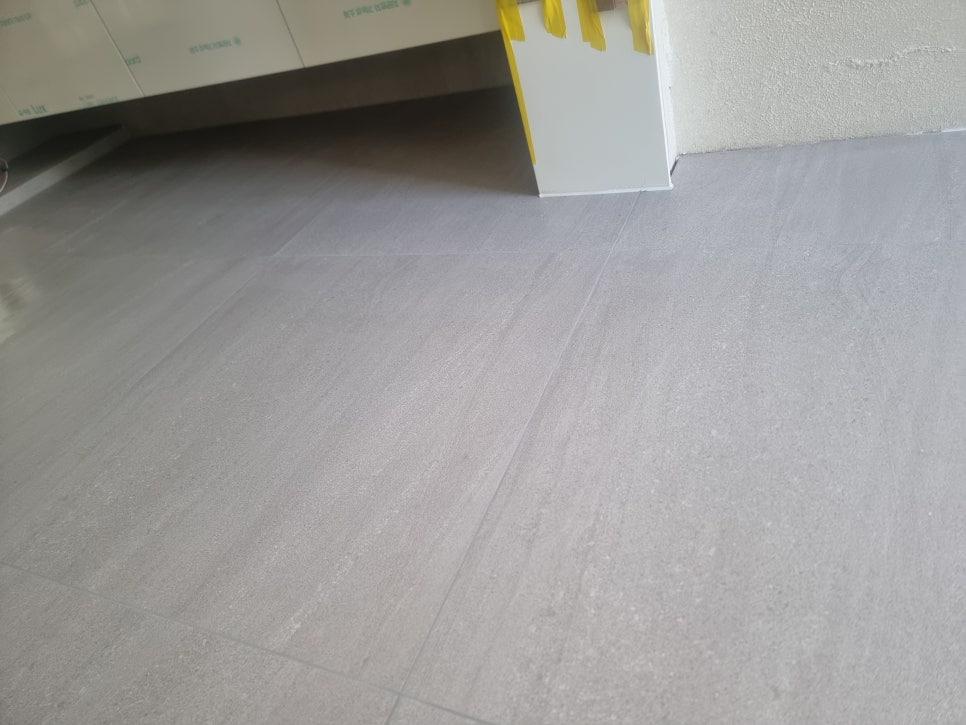 회색 타일 바닥과 가구 하단부의 접합면