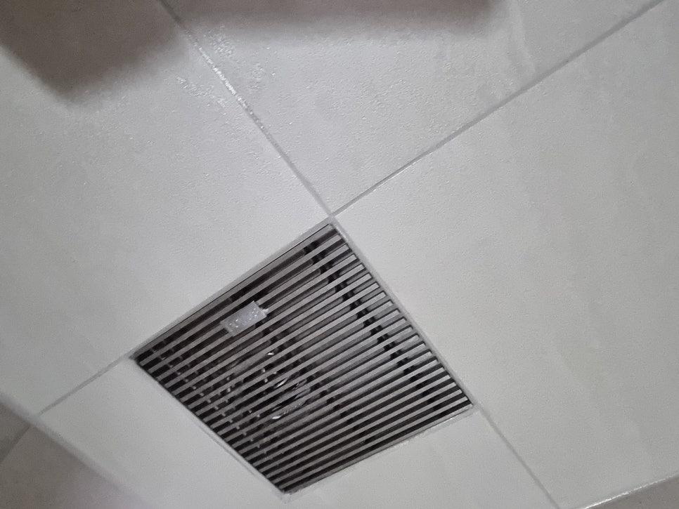 금속 라디에이터 그릴이 설치된 흰색 타일 벽면