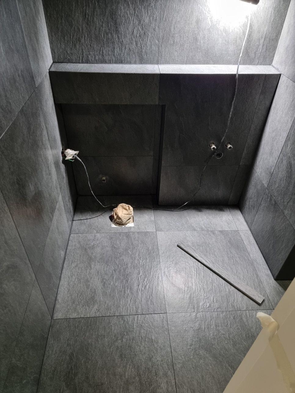 벽 타일 줄눈과 설비 일부가 보이는 모습