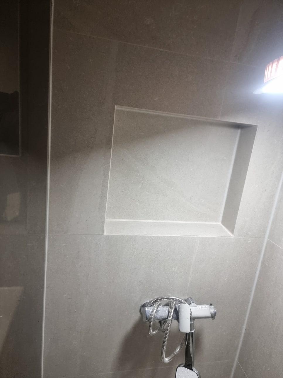 샤워 수전 주변의 타일 벽면 마감
