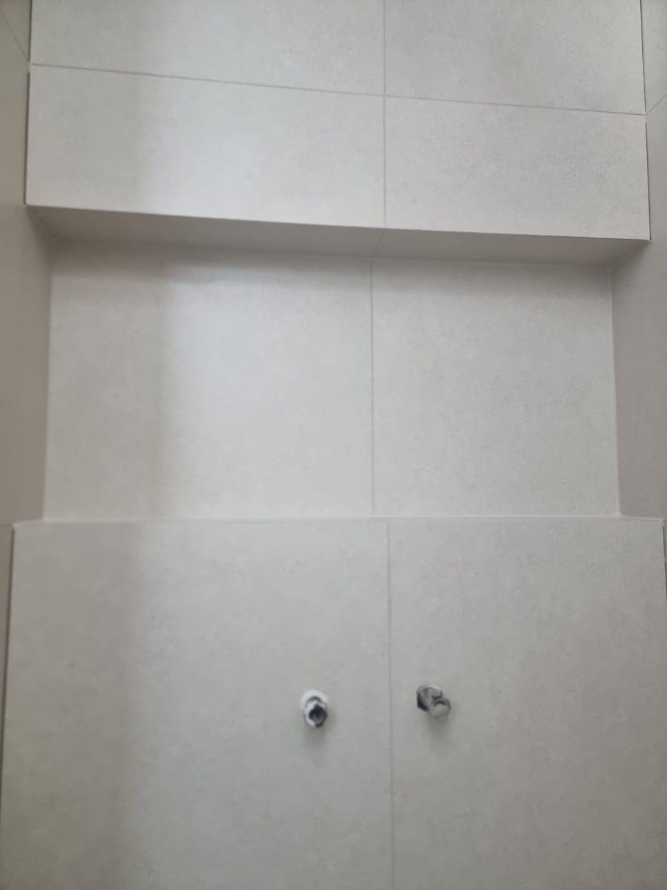 흰색 타일 벽면 하단의 원형 구멍