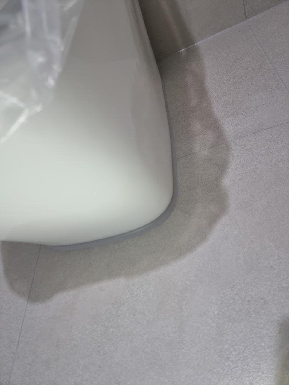 흰색 세면대 하단과 벽돌 바닥의 접합부