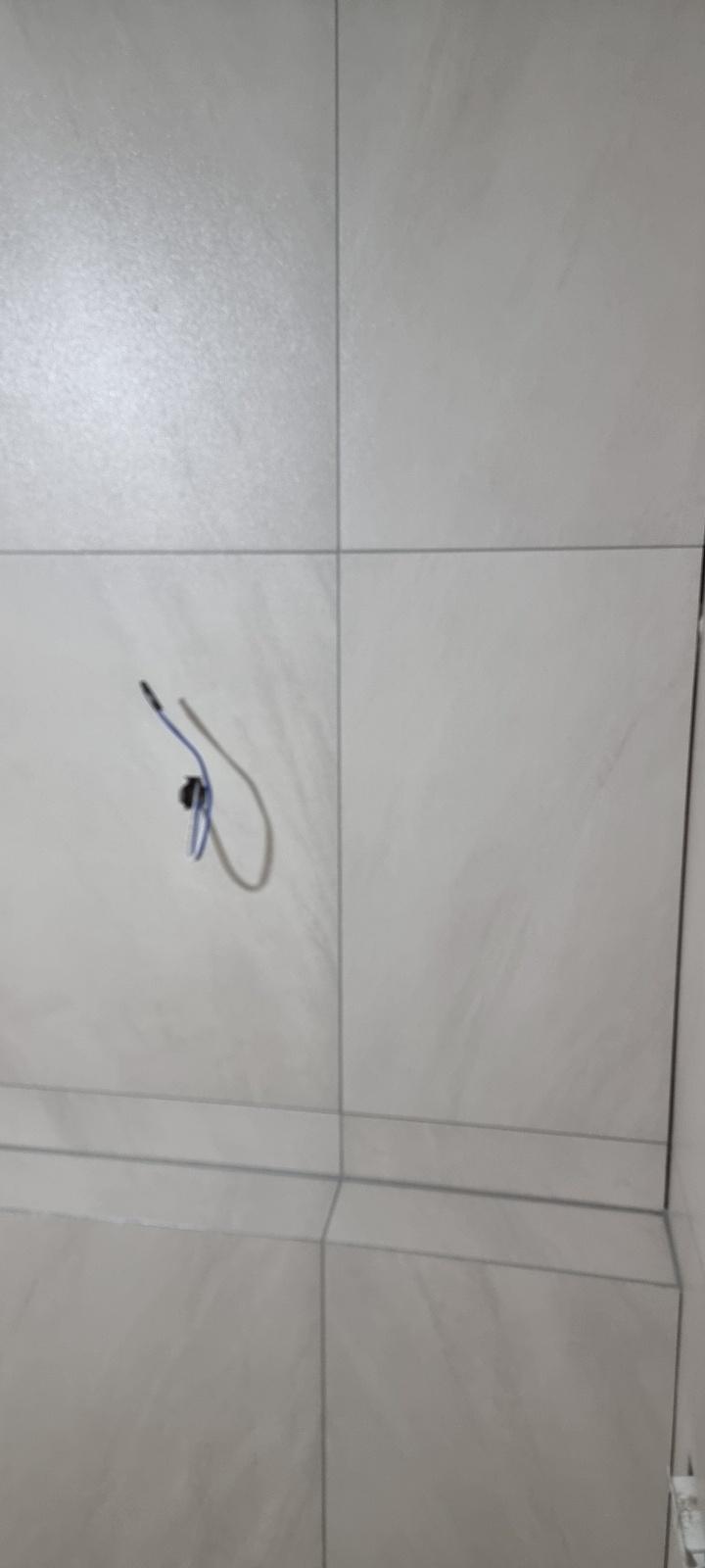 파란색과 검은색 전선이 노출된 타일 바닥