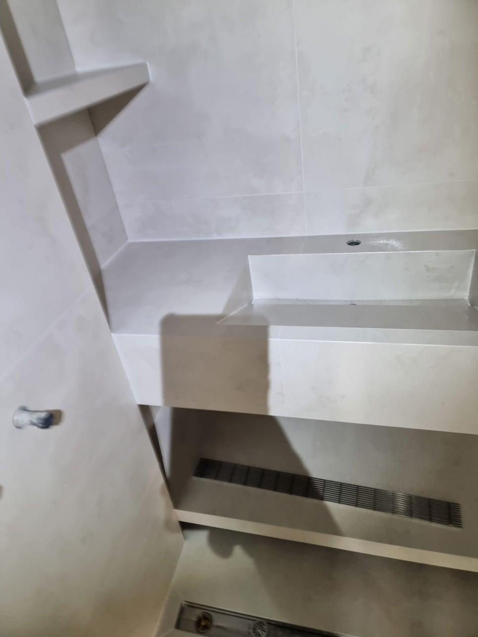 흰색 타일 벽면과 상판, 배수구가 있는 디테일