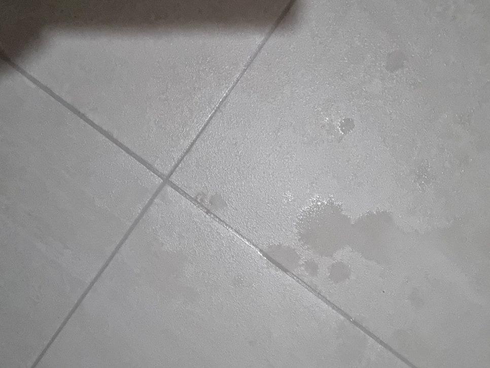 흰색 타일 바닥 위에 맺힌 물방울
