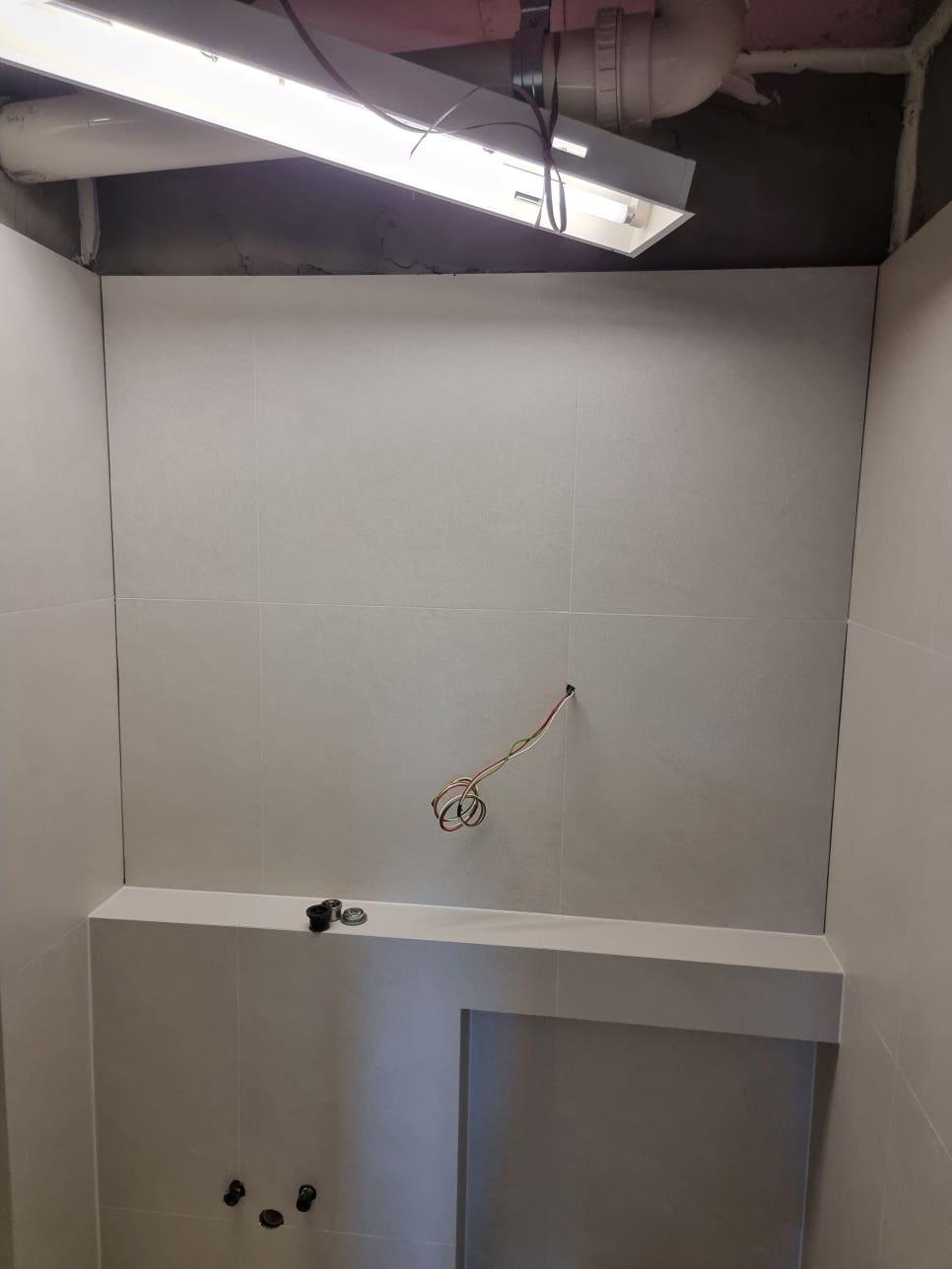 흰색 타일 벽면과 천장 배관 및 전선