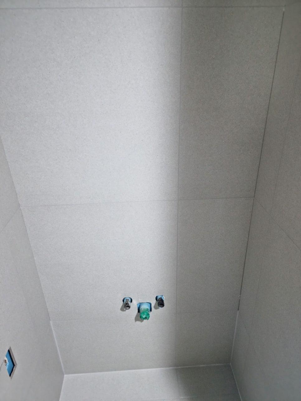 배관 구멍이 보이는 흰색 타일 벽면