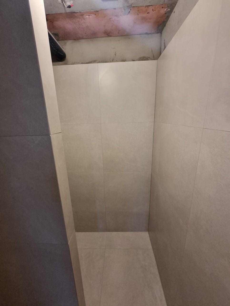 흰색 타일 벽과 바닥이 만나는 좁은 공간