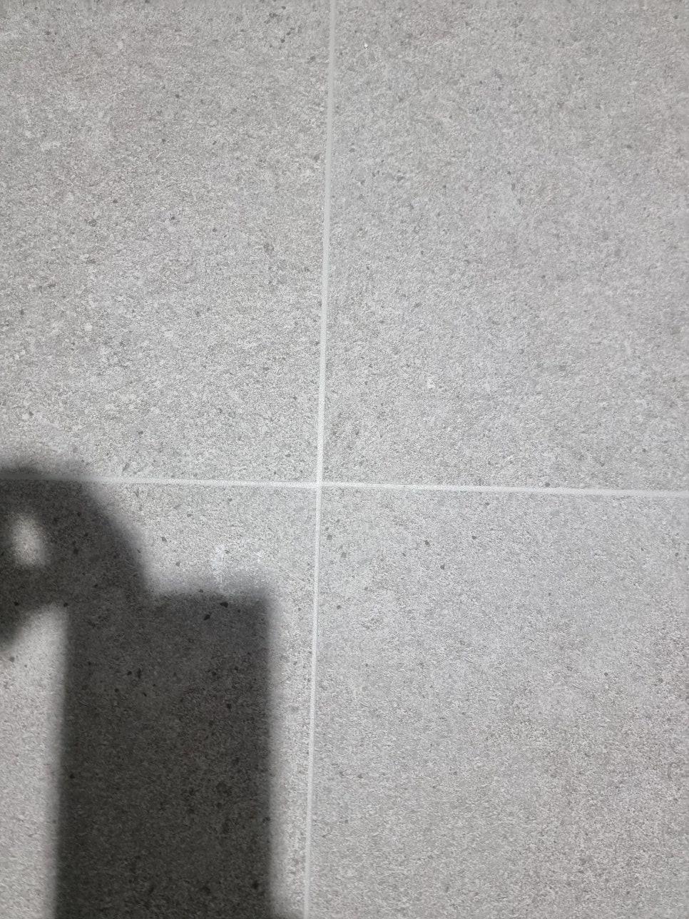 회색 타일 바닥의 흰색 틈새 근접 샷