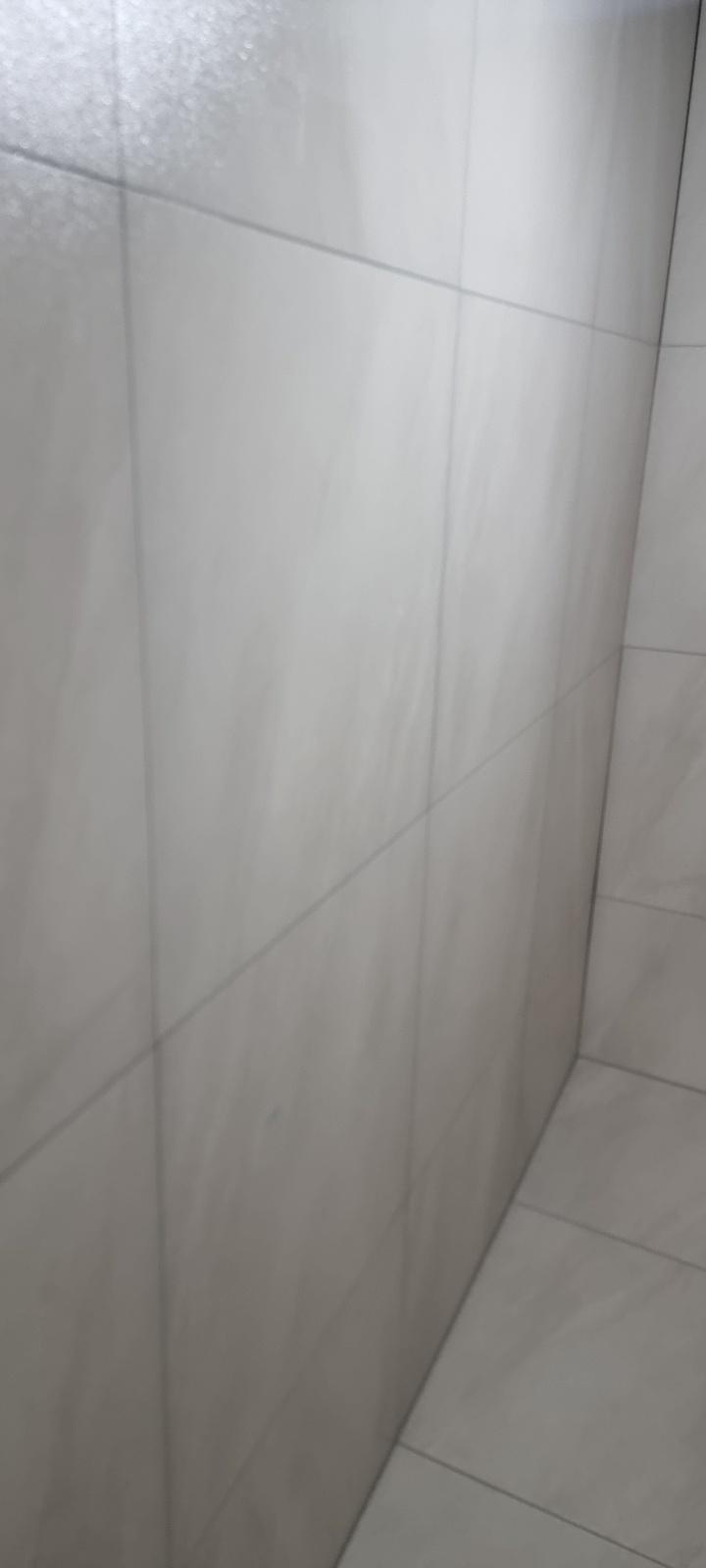 반짝임이 보이는 흰색 타일 벽과 바닥의 틈새