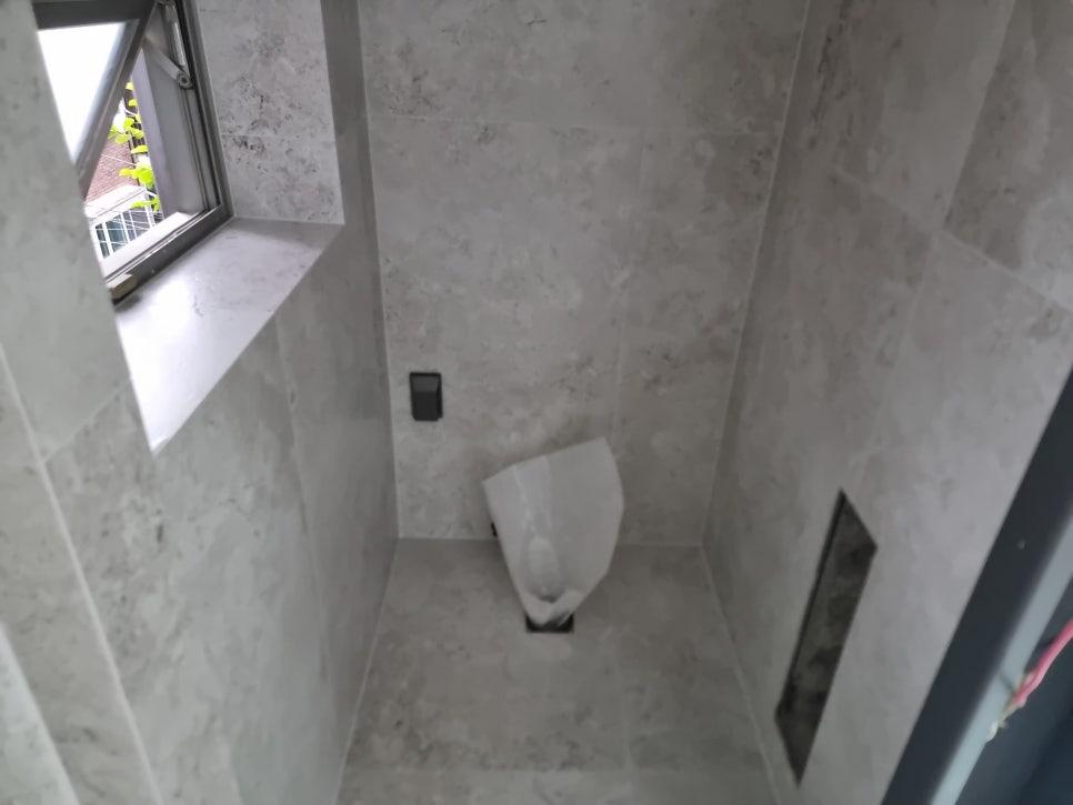 세면대가 설치된 회색 톤의 화장실 내부