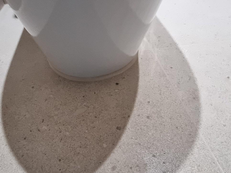컵 그림자가 비치는 깨끗한 흰색 타일 바닥