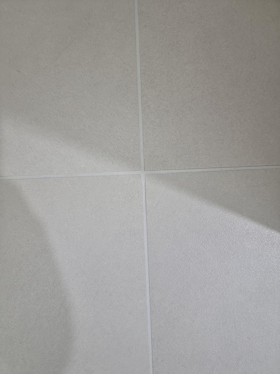흰색 타일 틈새에 채워진 흰색 실리콘 근접 샷