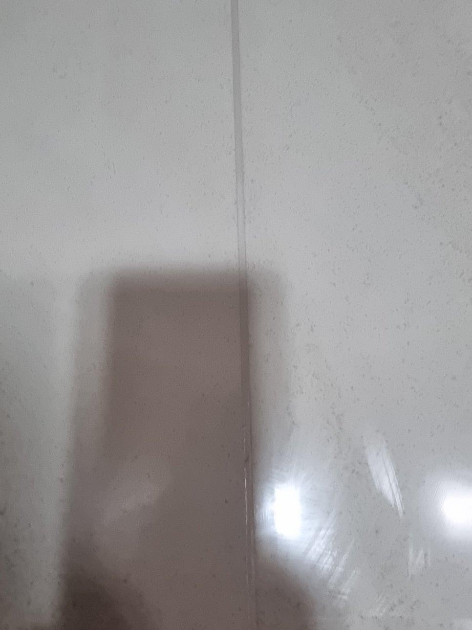 반사광이 보이는 흰색 타일 벽면의 틈