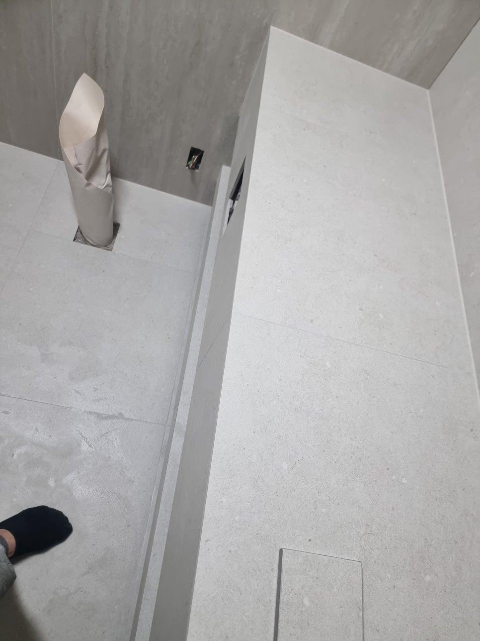흰색 타일 벽면의 전기 소켓과 작업 현장