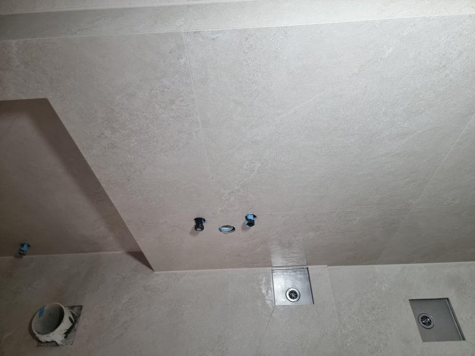 고정 장치와 금속 배수구가 보이는 천장