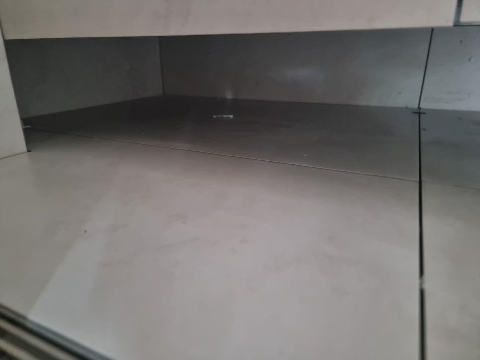 회색 벽면과 밝은 바닥재가 맞닿은 상단 접합부