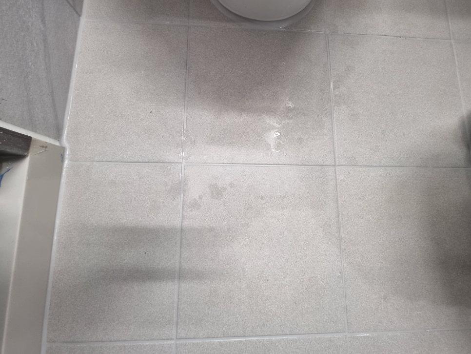 물방울이 맺힌 흰색 타일 바닥의 근접 모습