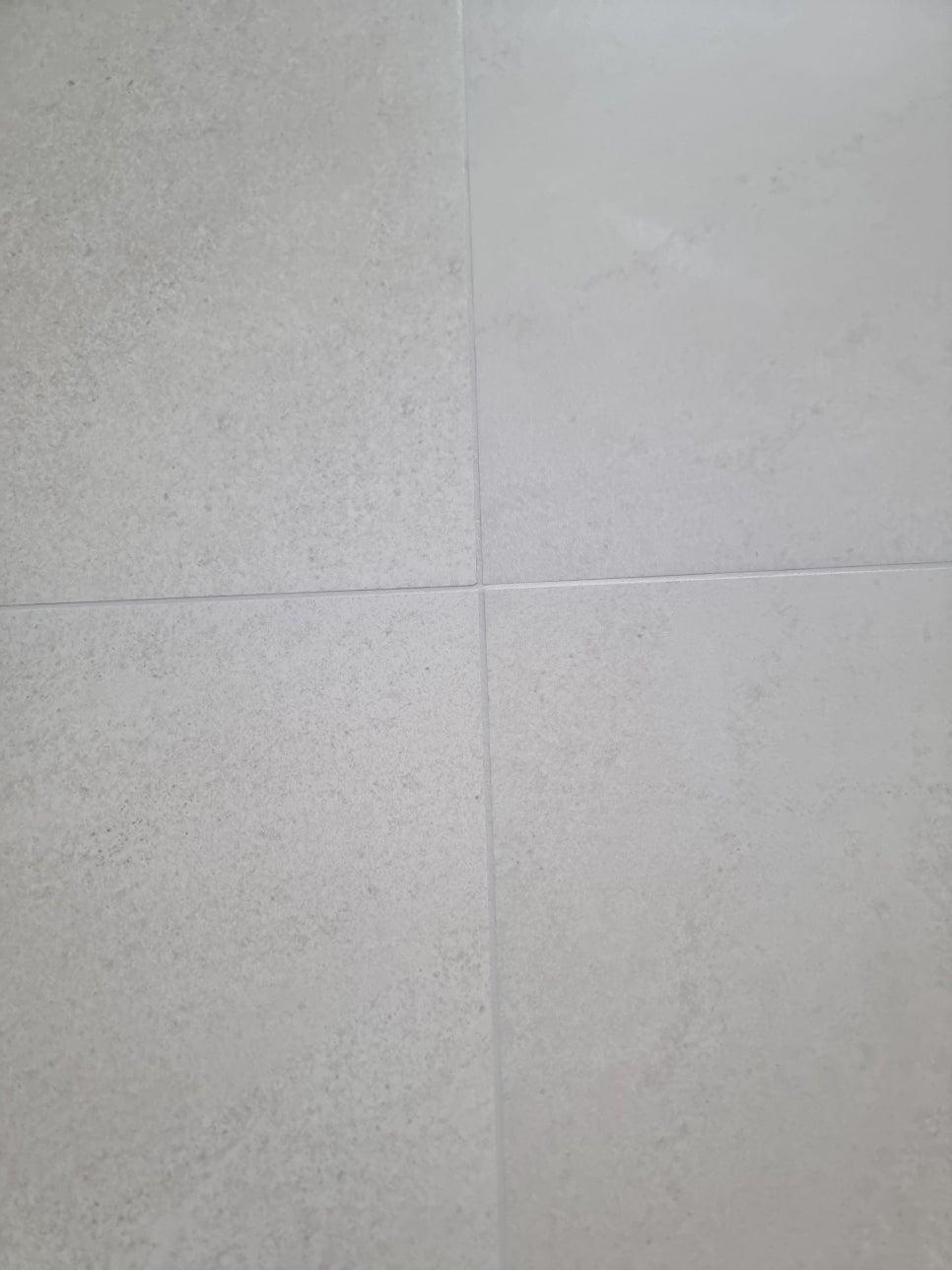 흰색 실리콘 접합제가 보이는 타일 바닥