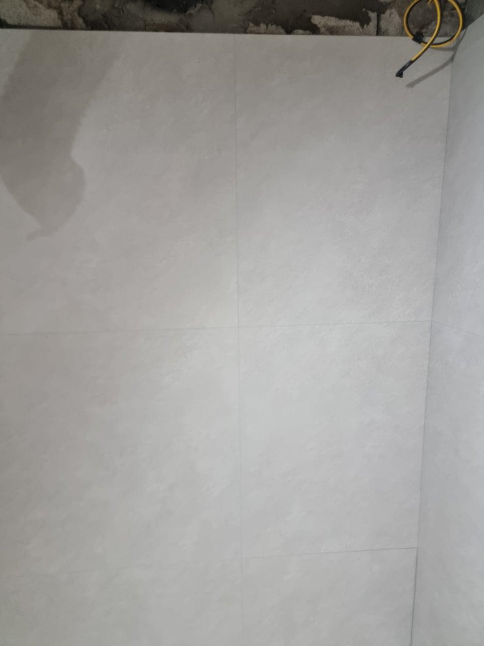노란 전선이 노출된 흰색 타일 벽면