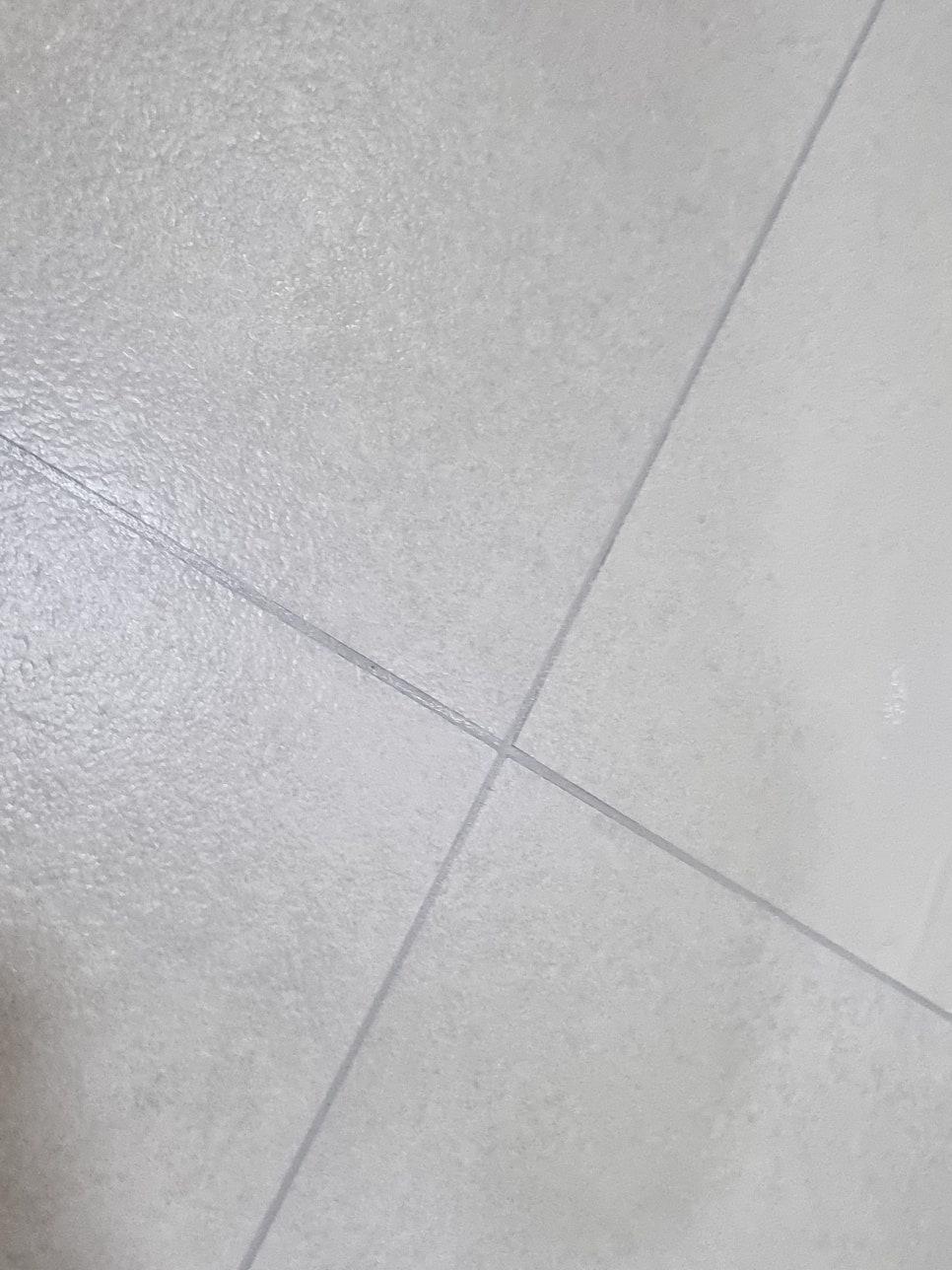흰색 타일과 세라믹 타일 사이의 흰색 실리콘 접합제