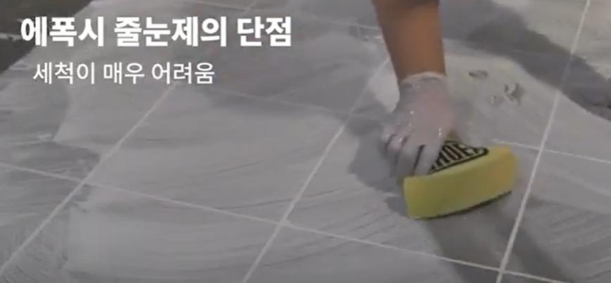 노란색 스크래퍼로 타일 바닥을 세척하는 과정