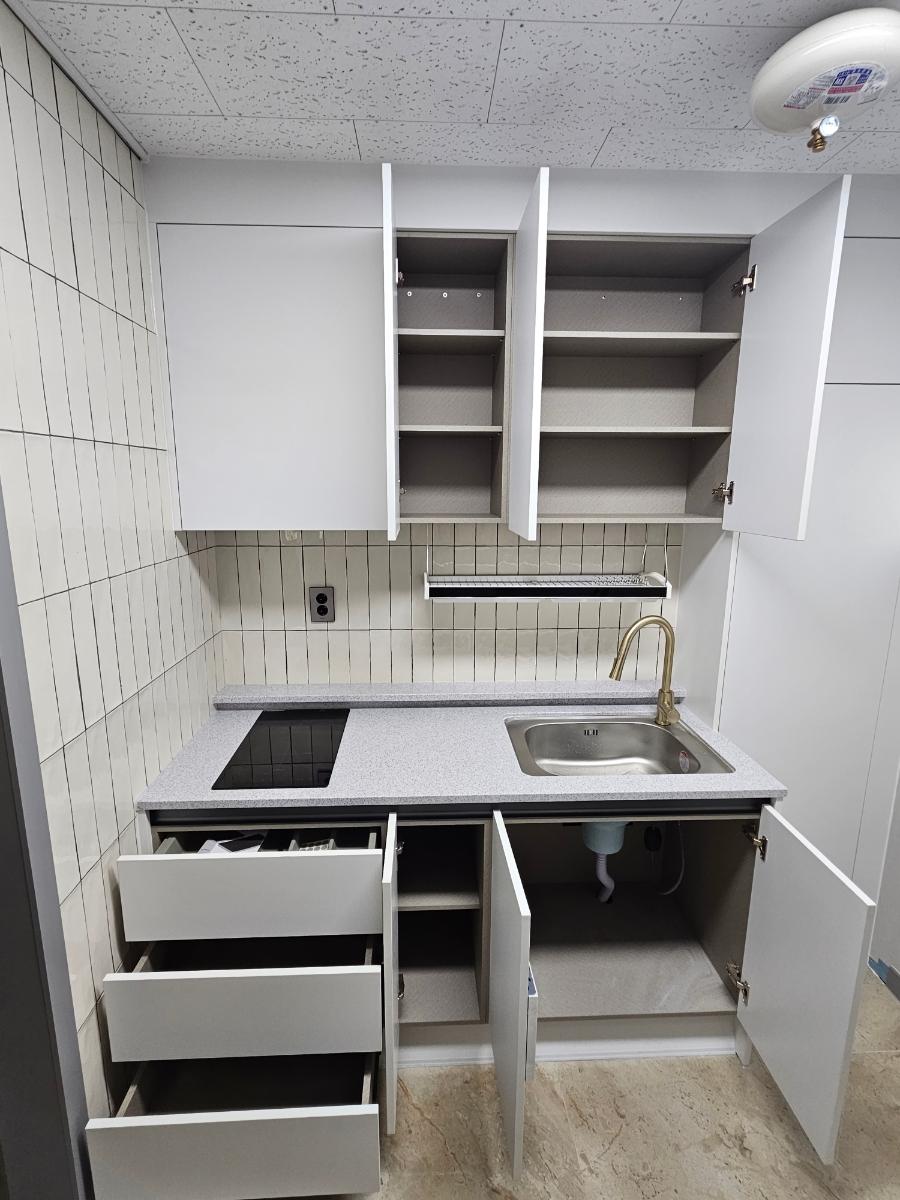 화이트 타일 벽면과 정갈하게 배치된 상하부장