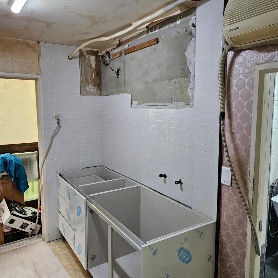 흰색 타일 벽면과 수납장 구조가 보이는 시공 과정