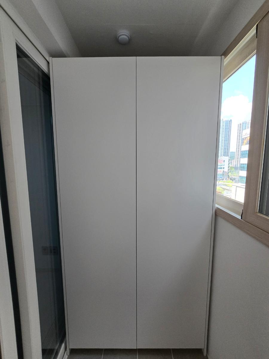 창문 옆 타일 바닥에 설치 중인 베란다장