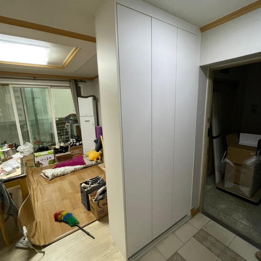 창가 옆에 배치된 흰색 높은 수납장