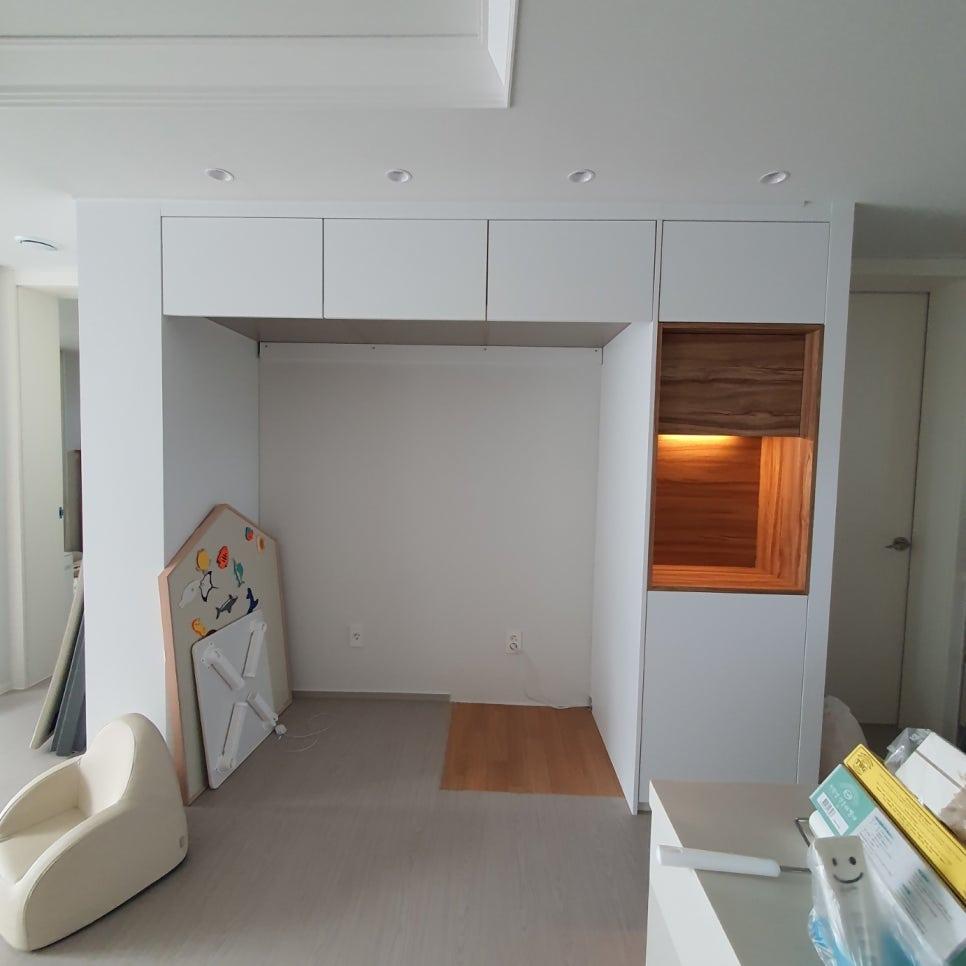 회색 마루와 나무 패널 조명이 어우러진 아이방