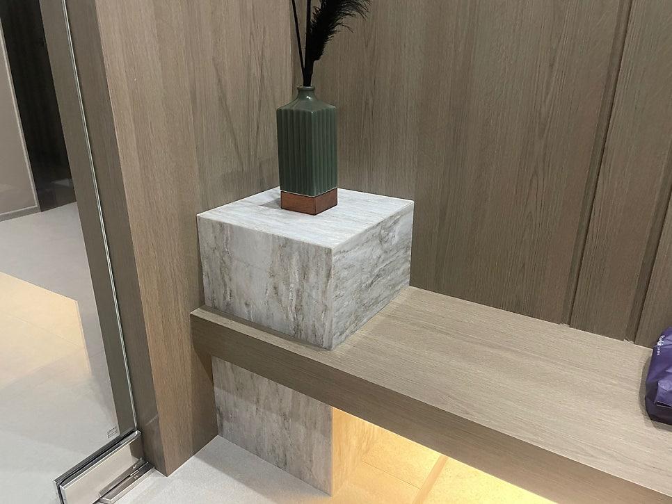 나무 패널 벽과 마블 소재 큐브 구조물