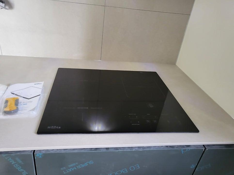 화이트 상판 위에 매립된 검은색 인덕션과 도어 디테일