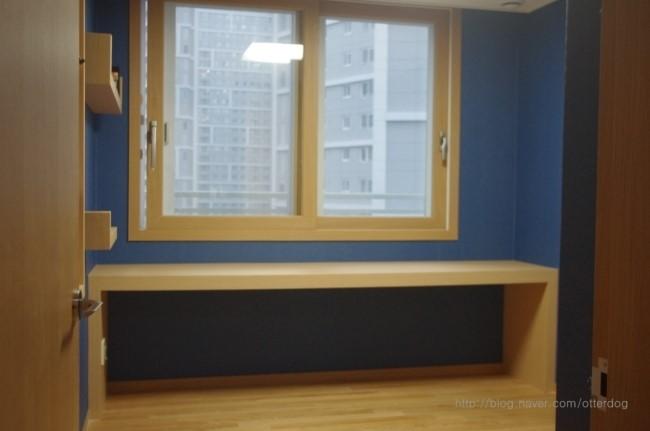 베이지색 창호와 하단 수납장이 설치된 창가