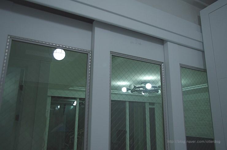 회색 벽면과 대비되는 유리 패널 슬라이딩 도어