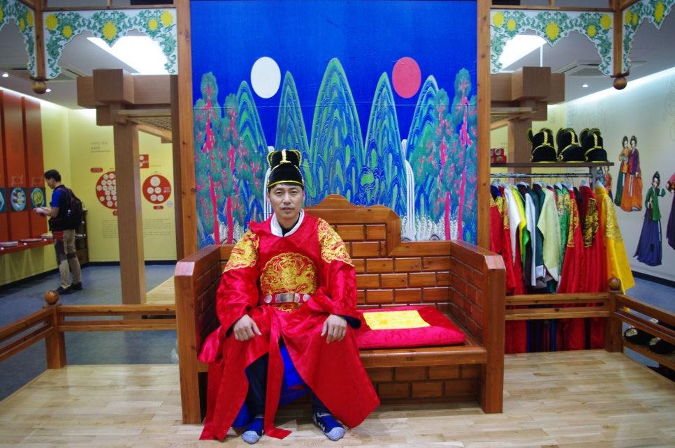 목재 왕좌와 벽화가 있는 이색적인 전시 공간