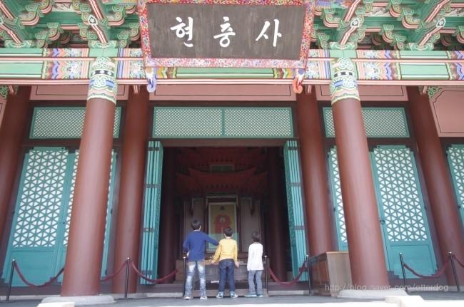 붉은 기둥과 녹색 창문이 돋보이는 현충사 입구